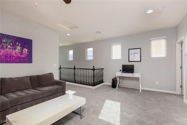 carpeted living room featuring attic access, baseboards, a wealth of natural light, and recessed lighting