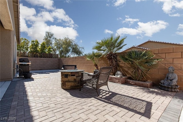 view of patio featuring an outdoor fire pit, a fenced backyard, and grilling area