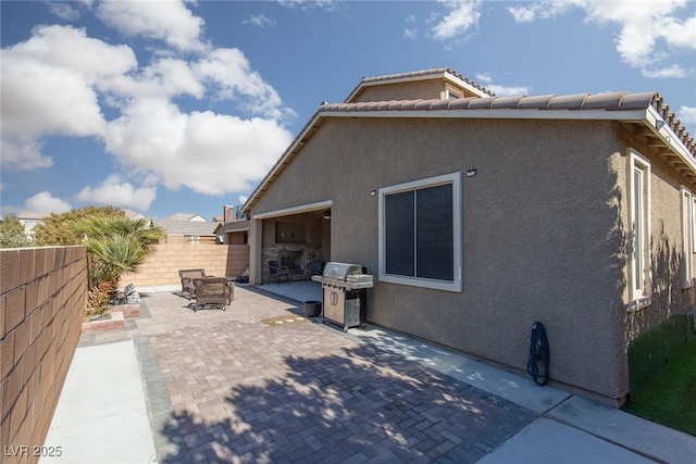 rear view of property with a tiled roof, a patio area, a fenced backyard, and stucco siding