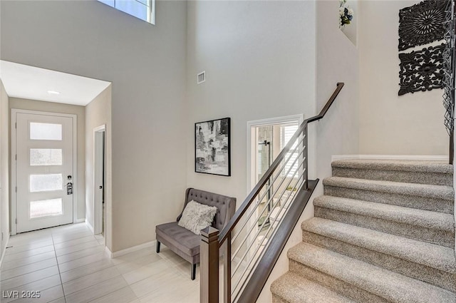 tiled foyer entrance featuring a towering ceiling and plenty of natural light