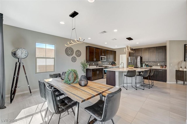 dining space featuring sink and light tile patterned floors