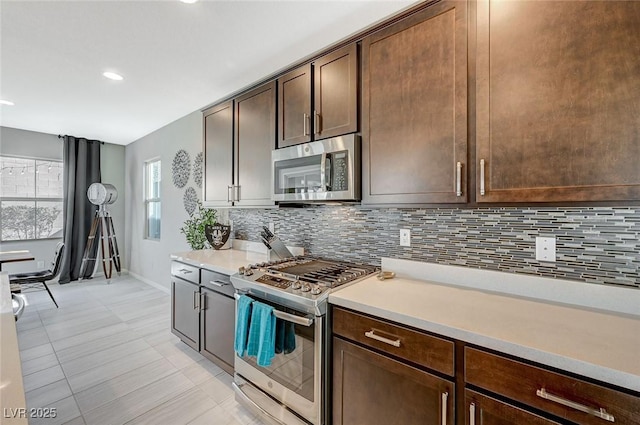 kitchen featuring dark brown cabinetry, appliances with stainless steel finishes, and decorative backsplash