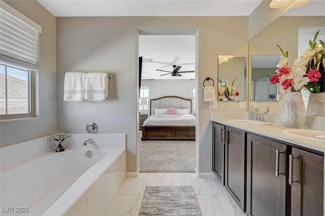 bathroom featuring vanity, ceiling fan, a relaxing tiled tub, and a healthy amount of sunlight