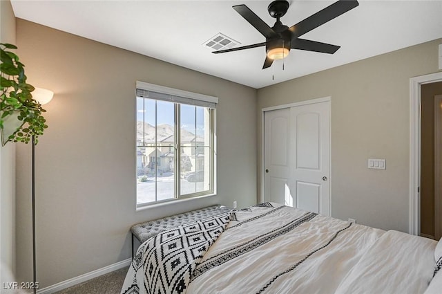 carpeted bedroom with ceiling fan and a closet