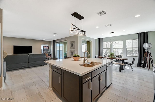 kitchen featuring pendant lighting, an island with sink, sink, stainless steel dishwasher, and plenty of natural light