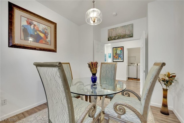 dining area featuring washer and clothes dryer and light wood-type flooring