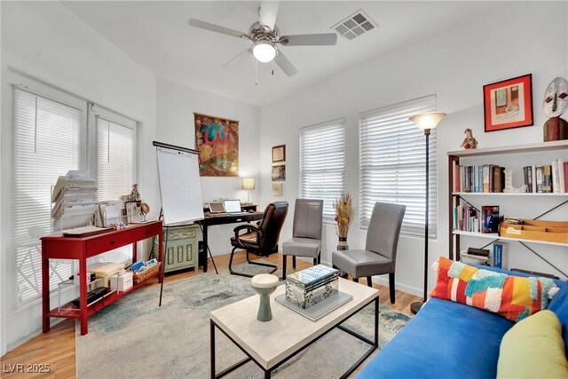 living room with ceiling fan and light wood-type flooring