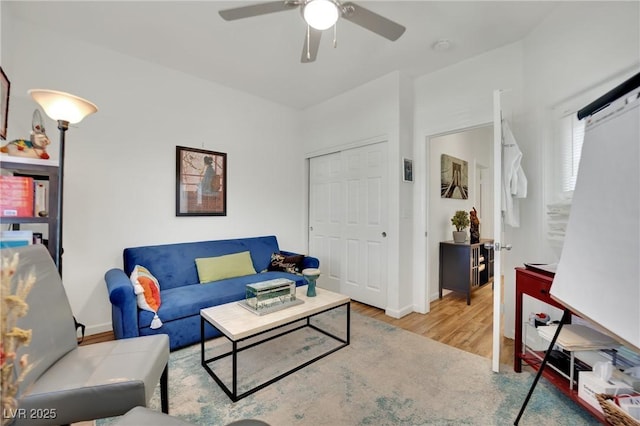 living room featuring ceiling fan and light hardwood / wood-style floors