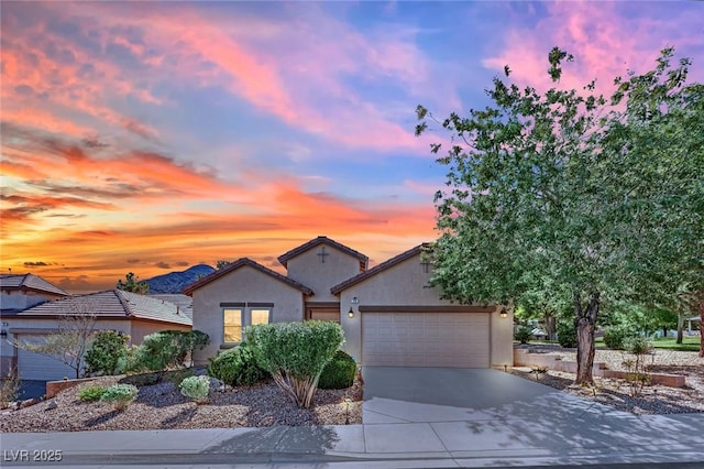 view of front of home featuring stucco siding, a garage, and driveway