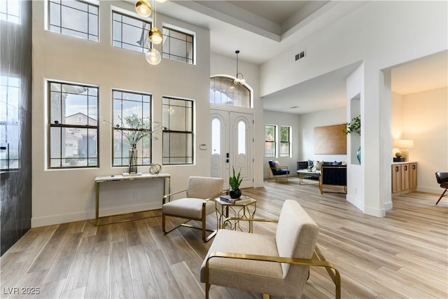 living area with light hardwood / wood-style flooring and a high ceiling