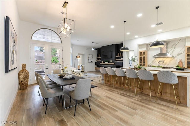 dining space featuring french doors, ceiling fan, and light hardwood / wood-style flooring