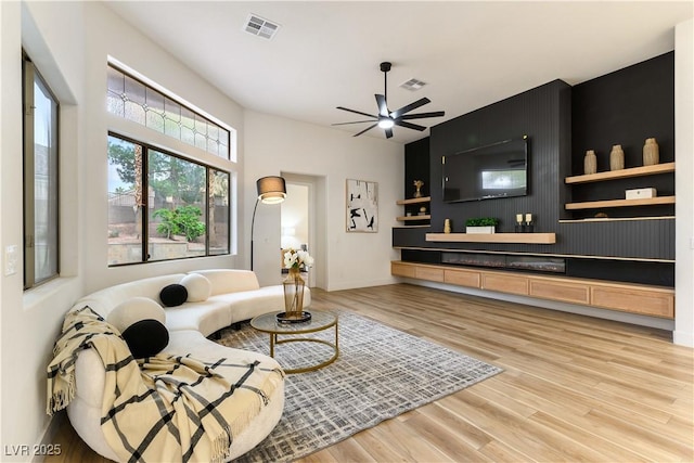 living room with light hardwood / wood-style flooring and ceiling fan