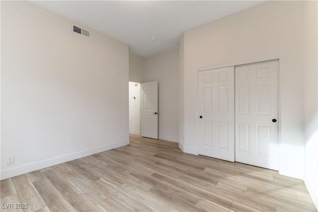 unfurnished bedroom with light hardwood / wood-style flooring and a closet