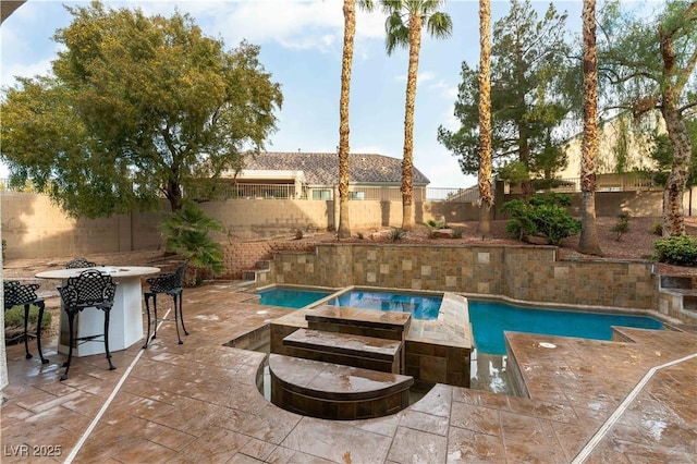 view of pool with an in ground hot tub, exterior bar, and a patio area