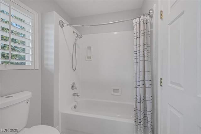 bathroom featuring shower / bath combination with curtain and toilet