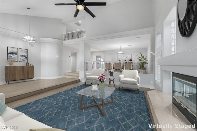 living room featuring hardwood / wood-style floors, ceiling fan with notable chandelier, and high vaulted ceiling