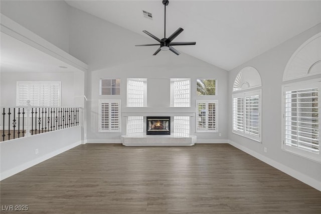 unfurnished living room featuring dark wood-type flooring, ceiling fan, and high vaulted ceiling