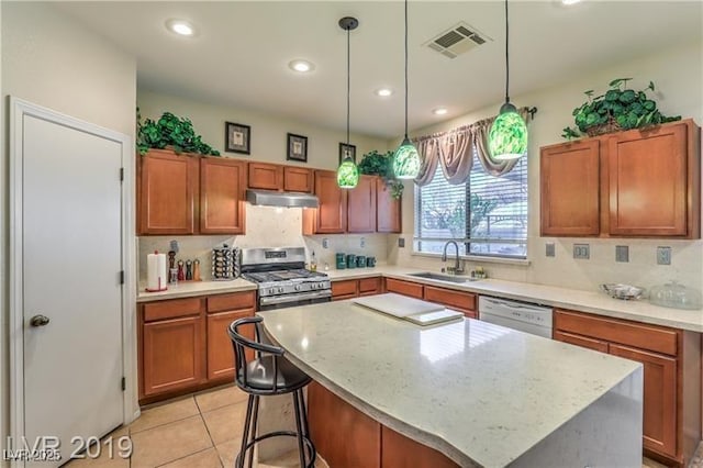 kitchen with a kitchen island, stainless steel gas stove, dishwasher, sink, and hanging light fixtures