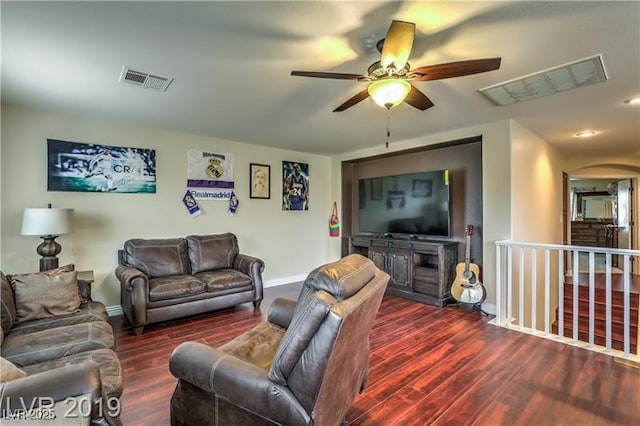 living room featuring dark wood-type flooring and ceiling fan