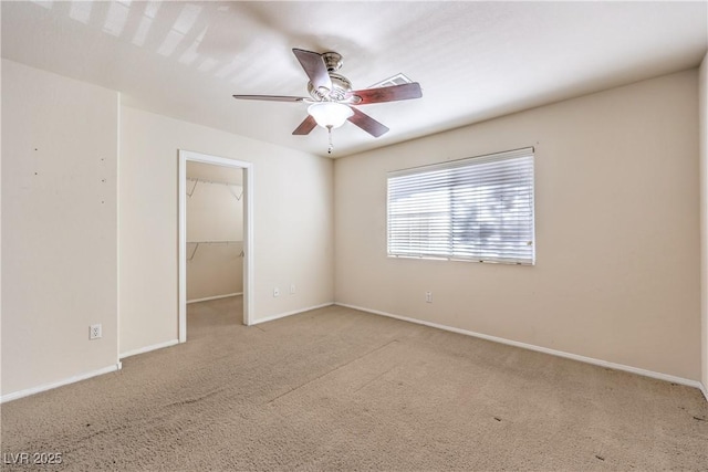 empty room featuring ceiling fan and light colored carpet