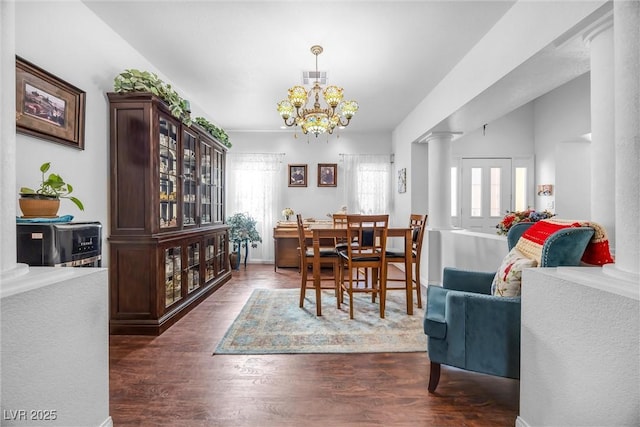 dining area with decorative columns, plenty of natural light, dark wood-type flooring, and a chandelier