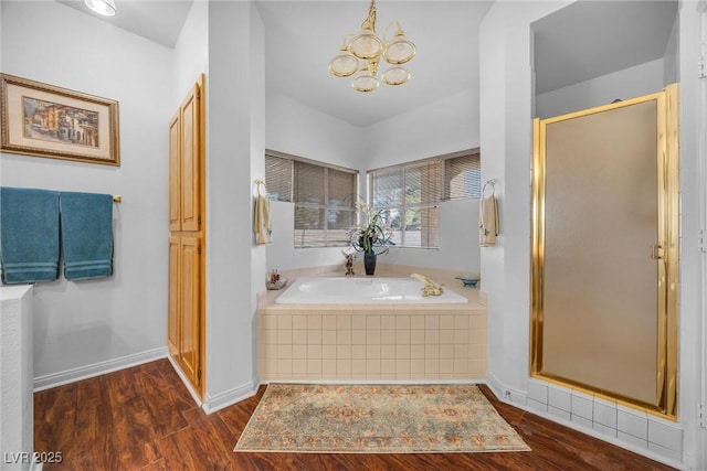 bathroom featuring hardwood / wood-style flooring, shower with separate bathtub, and a notable chandelier