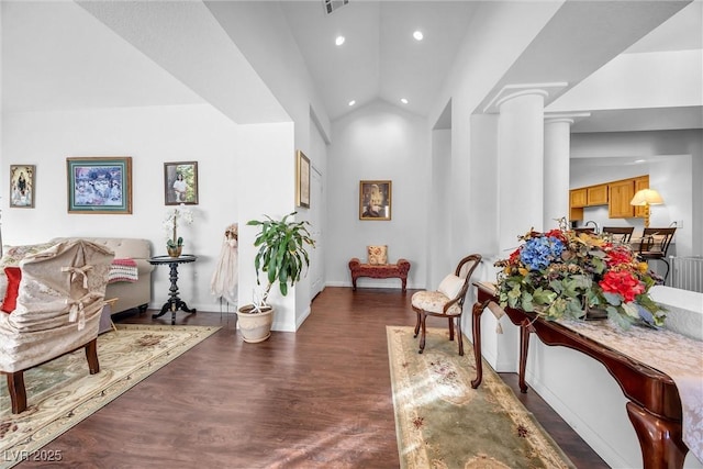 interior space with ornate columns, high vaulted ceiling, and dark hardwood / wood-style flooring