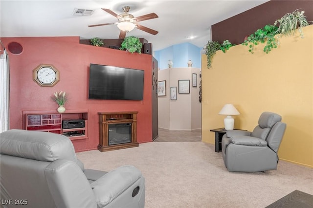 carpeted living room with ceiling fan and lofted ceiling