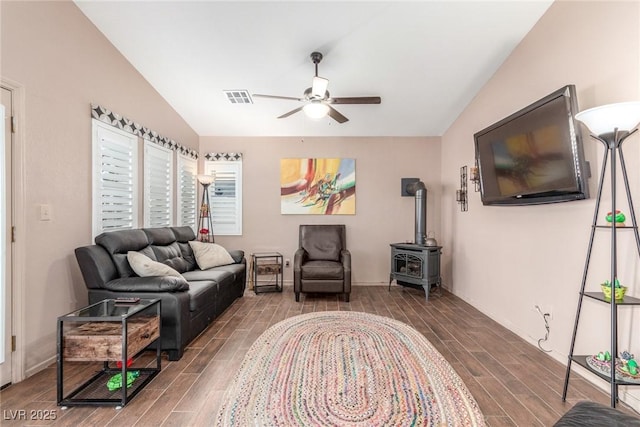 living room featuring ceiling fan, lofted ceiling, and a wood stove