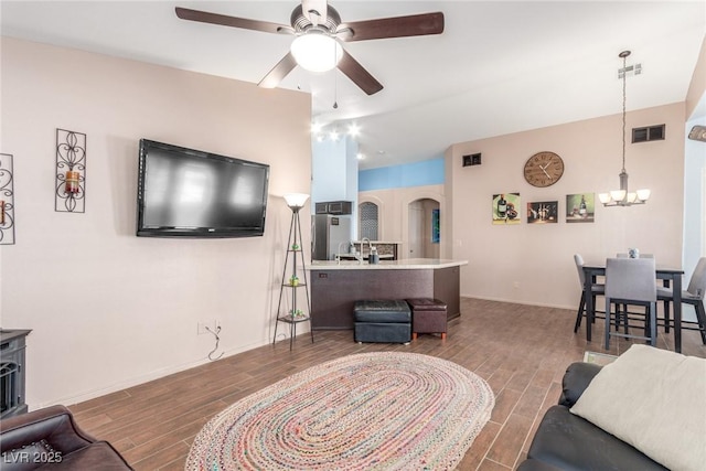 living room featuring ceiling fan with notable chandelier