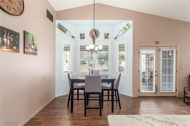 dining area featuring an inviting chandelier, vaulted ceiling, and french doors