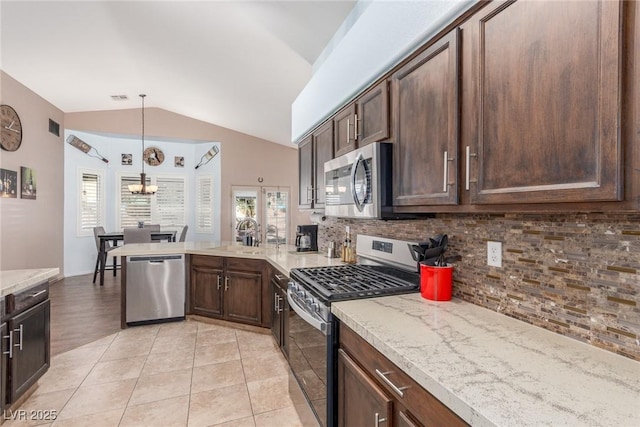 kitchen with dark brown cabinetry, appliances with stainless steel finishes, kitchen peninsula, pendant lighting, and decorative backsplash