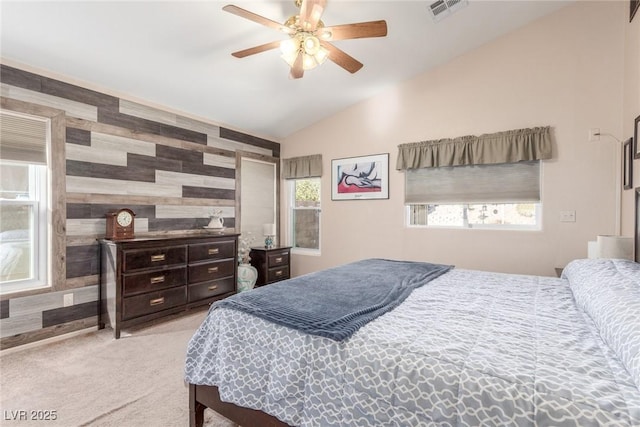 carpeted bedroom featuring multiple windows, vaulted ceiling, wooden walls, and ceiling fan