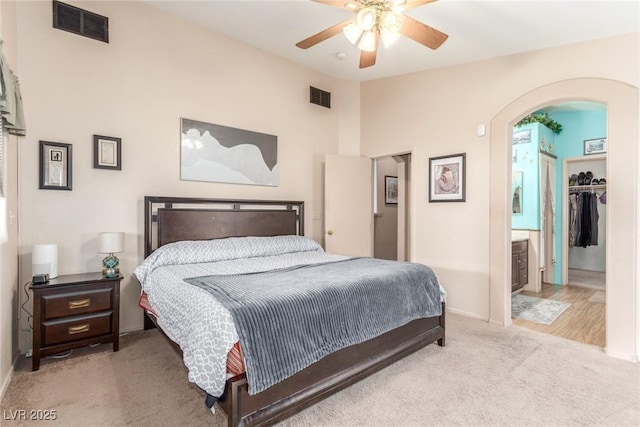 carpeted bedroom featuring ceiling fan, lofted ceiling, and connected bathroom