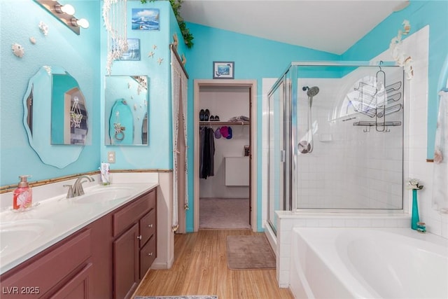 bathroom featuring hardwood / wood-style flooring, lofted ceiling, vanity, and separate shower and tub