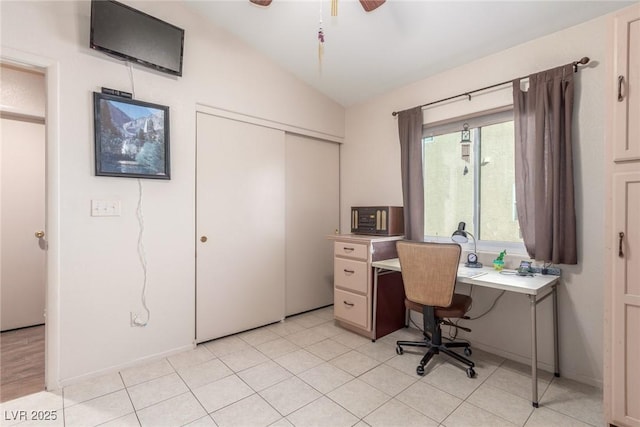 home office featuring lofted ceiling, ceiling fan, and light tile patterned flooring