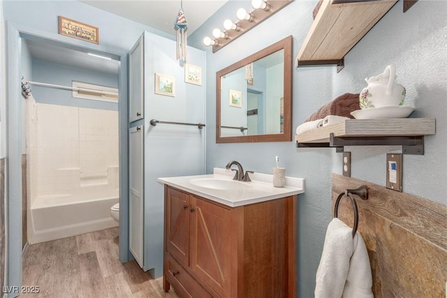 full bathroom with shower / tub combination, vanity, toilet, and hardwood / wood-style floors