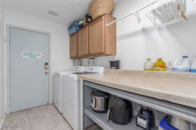 clothes washing area featuring independent washer and dryer and cabinets