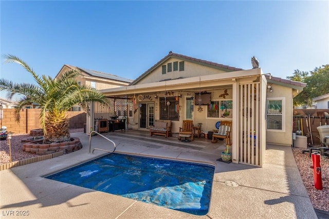 back of property featuring a patio area and a covered pool