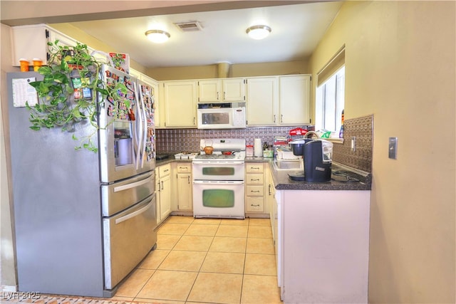 kitchen featuring sink, light tile patterned floors, white appliances, and decorative backsplash