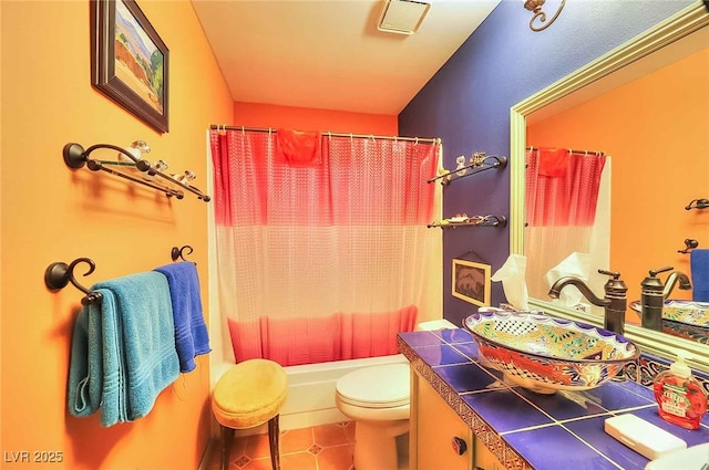 full bathroom featuring vanity, shower / tub combo with curtain, tile patterned floors, and toilet