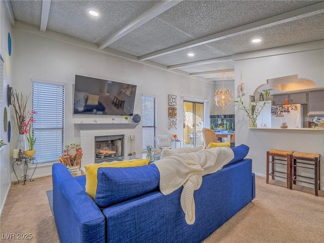 carpeted living room with beam ceiling and a textured ceiling