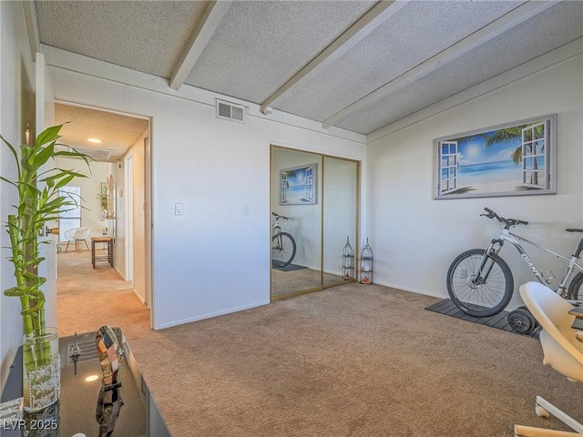 misc room with carpet flooring, lofted ceiling with beams, and a textured ceiling