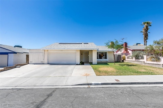 single story home with a garage, a front lawn, and solar panels