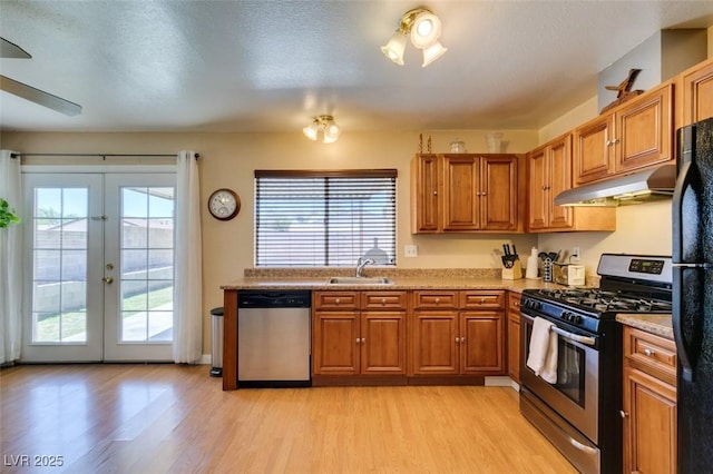 kitchen with appliances with stainless steel finishes, sink, a wealth of natural light, and light hardwood / wood-style flooring