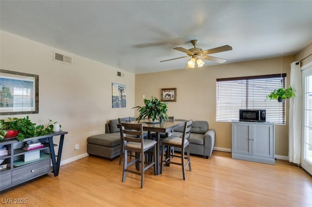 dining area with ceiling fan and light wood-type flooring