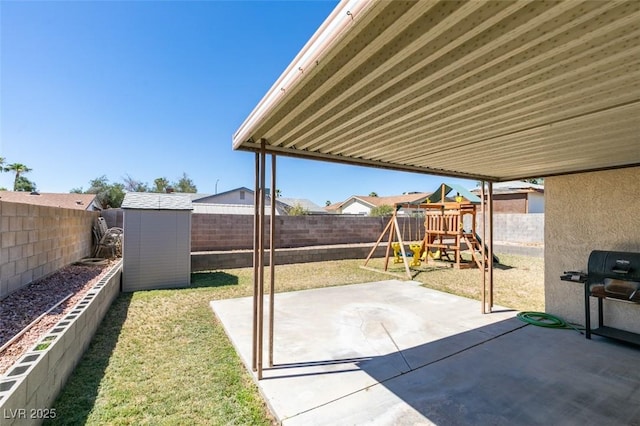 view of patio / terrace featuring a playground, area for grilling, and a storage shed