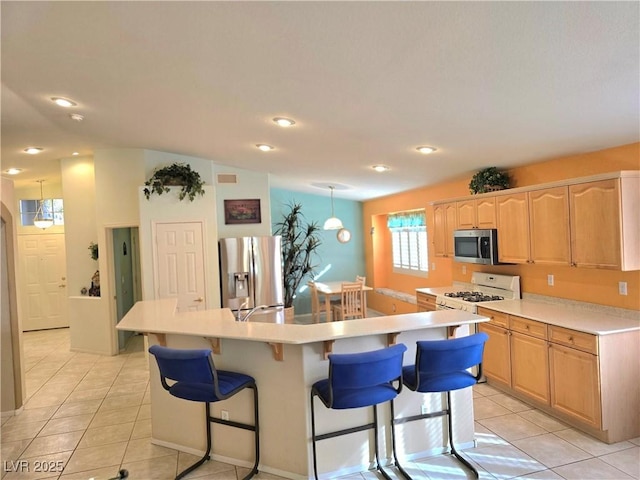 kitchen featuring stainless steel appliances, an island with sink, light brown cabinets, and light tile patterned floors