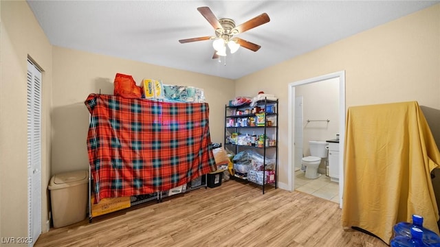 bedroom featuring ceiling fan, connected bathroom, and wood finished floors