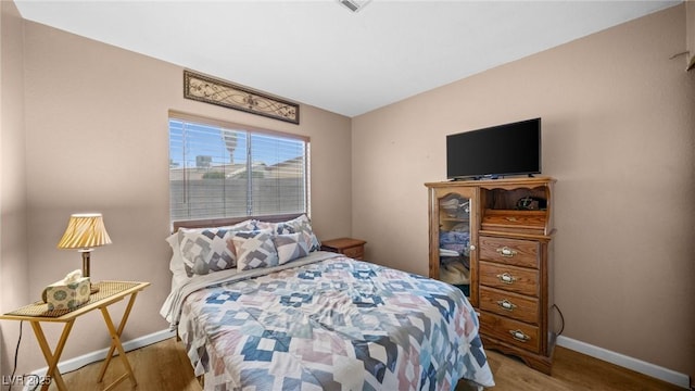 bedroom with wood finished floors and baseboards